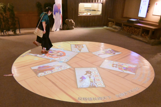 床に投影された映像をタッチして遊ぶカルタ